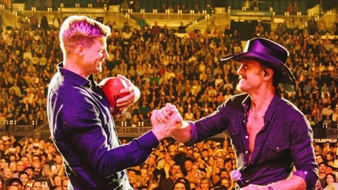 Article heading image for Nick Riewoldt Joined Tim McGraw On Stage To Kick Footys Into The Crowd